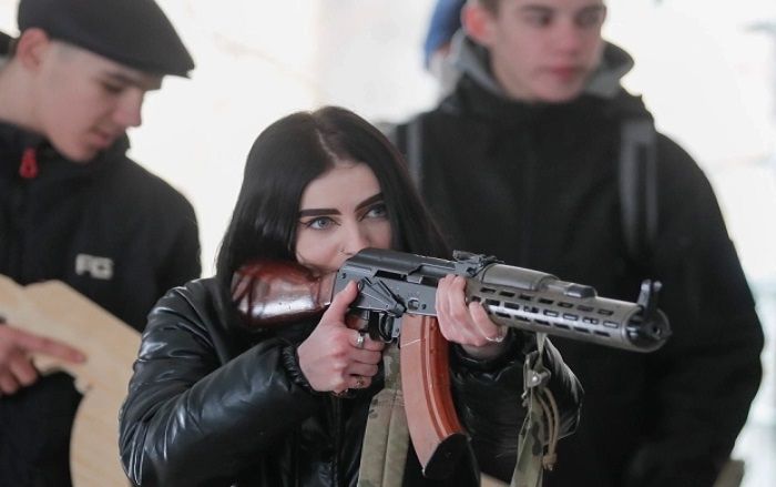 Seorang wanita Ukraina belajar menggunakan senjata.*  