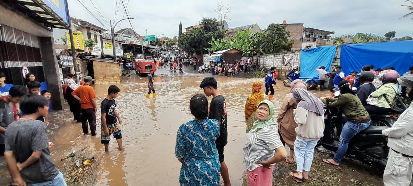 Warga menyaksikan evakuasi kendaraan yang terendam banjir di Jalan Anggaraja Kelurahan Cipageran Kecamatan Cimahi Utara Kota Cimahi usai sejumlah wilayah di Kota Cimahi diguyur hujan deras selama 1 jam.
