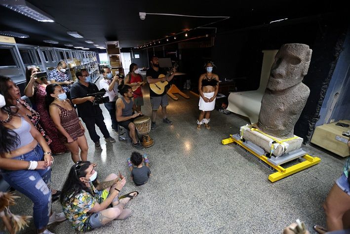 Penduduk asli Rapa Nui memainkan musik ke patung Moai dari Pulau Paskah saat ditampilkan di Museum Sejarah Alam sebelum kembali ke pulau itu, di Santiago, Chili, 21 Februari 2022.