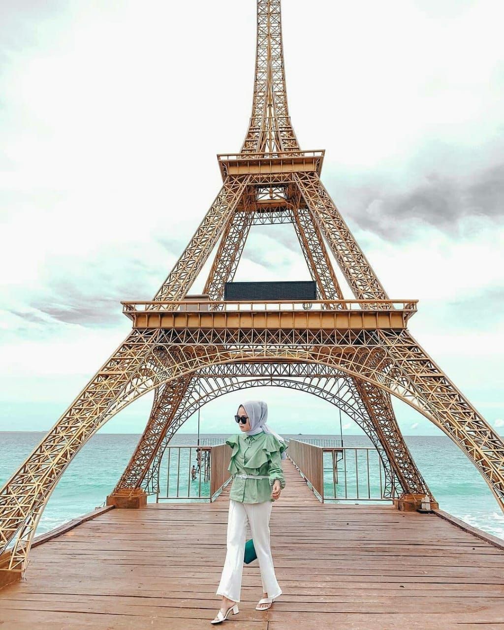 Seorang pengunjung tengah berfoto di miniatur Menara Eiffel, Pantai Ciputih.