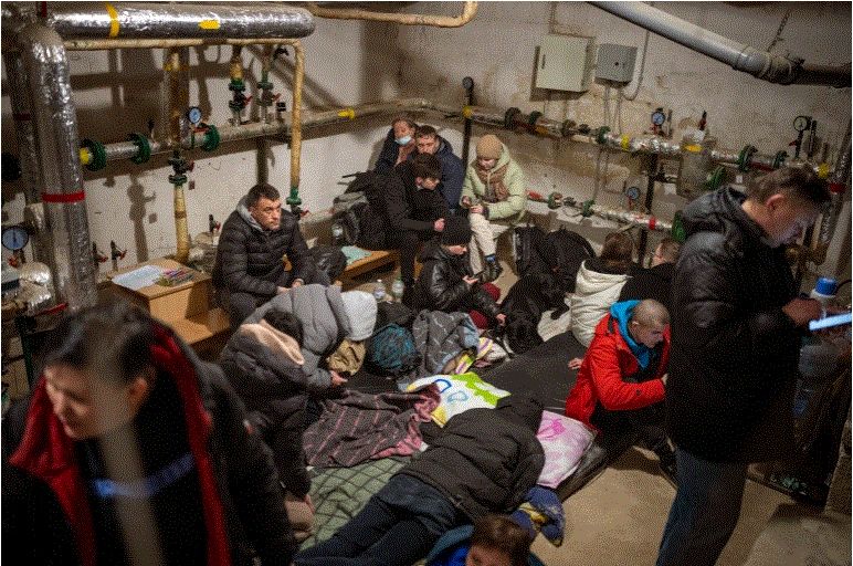Orang-orang berlindung di ruang bawah tanah gedung saat sirene mengumumkan serangan baru di kota Kyiv .