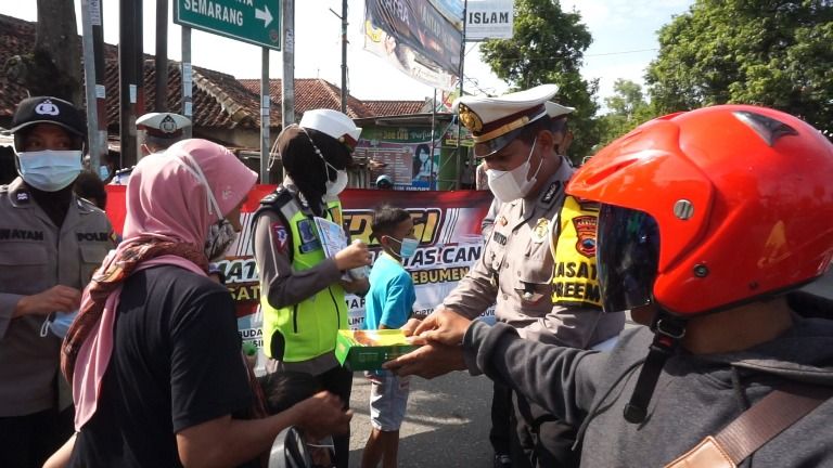 Personel Polres Kebumen bagikan nasi kotak untuk pengguna jalan yang tertib berlalu lintas dan taak prokes pada Operasi Keselamatan Lalu Lintas Candi (OKLC) 2022