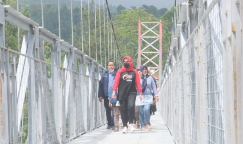 Bupati Klaten melintasi Jembatan Gantung Merah Putih, akses penghubung ke Dusun Girpasang, Desa Girimulyo yang dulu terpencil karena terhalang tebing atau jurang sangat curam
