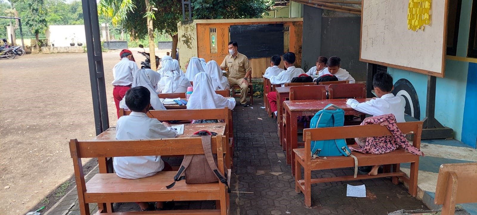 Siswa SDN Muneng Kidul Kecamatan Sumberasih Kabupaten Probolinggo belajar di teras toilet. 
