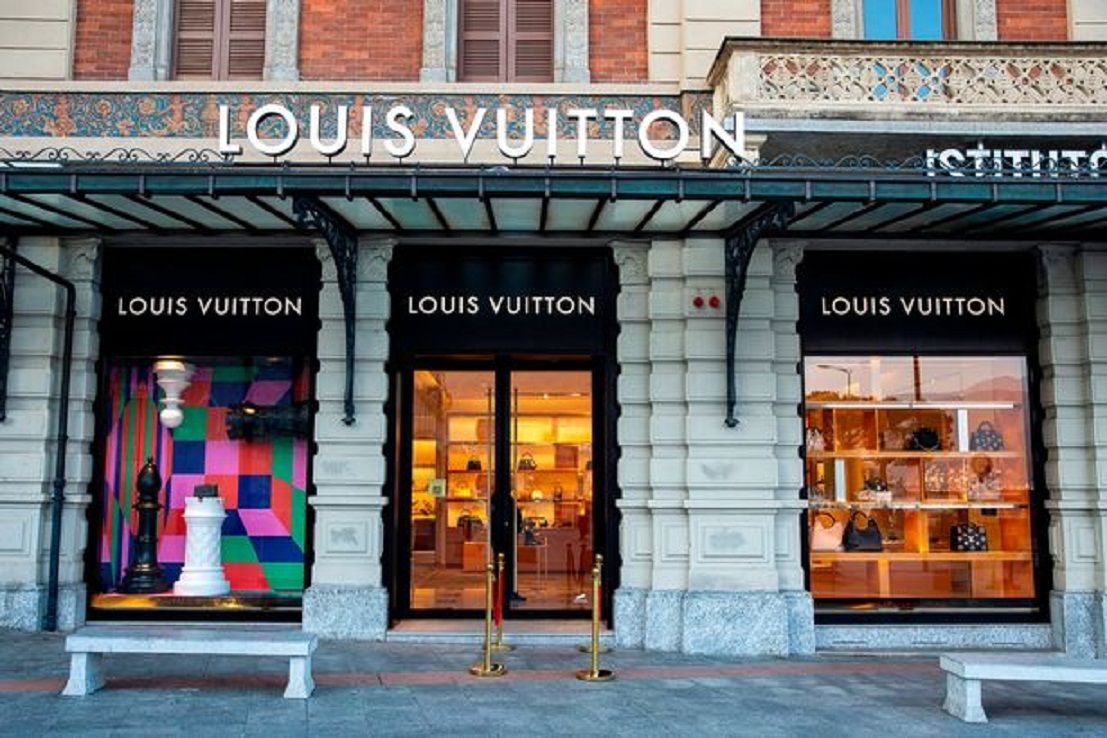 Orang-orang berjalan melalui kawasan penjaja mode kelas atas termasuk Louis Vuitton, Gucci dan Prada./