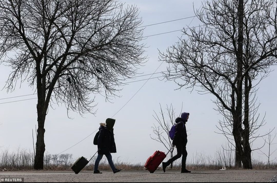 Pengungsi menyusuri di sepanjang jalan saat mereka meninggalkan kota selama konflik Ukraina-Rusia di pelabuhan selatan Mariupol, Ukraina yang terkepung./  