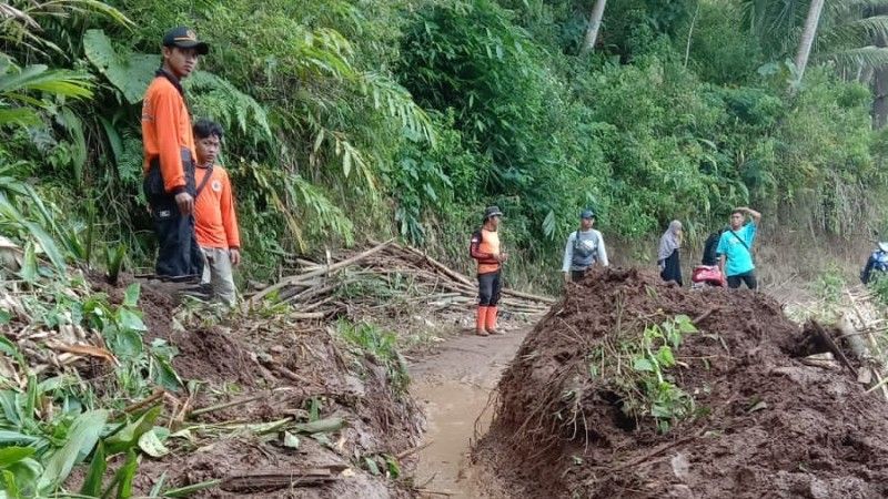 Warga dan petugas gabungan membersihkan materian longsor yang menutup jalan penghubung Mayana-Tambak Serang, Kecamatan Bantarkawung, Brebes.