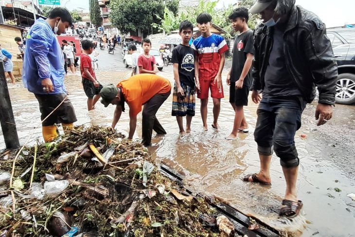 Petugas BPBD Kota Cimahi menyingkirkan sampah yang menyumbat drainase hingga mengakibatkan banjir di wilayah Padasuka Kota Cimahi.