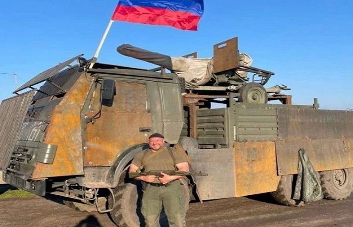 Satu foto menunjukkan tentara Rusia yang gemuk menyeringai di depan mobil karat yang telah banyak dimodifikasi.*  