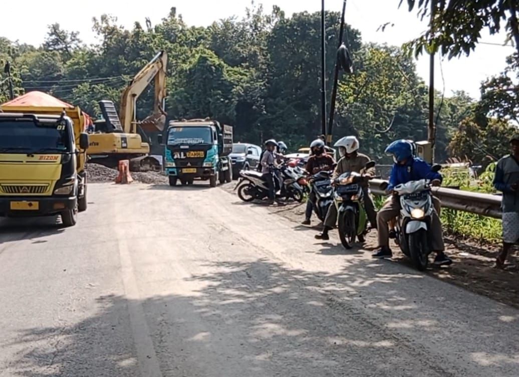 Terlihat para pekerja tengah memperbaiki jalan yang amblas, akibatnya hanya dibuka satu jalur dan diberlakukan buka tutup di Jalan Cireki Kecamatan Tomo Kabupaten Sumedang, Minggu 24 April 2022