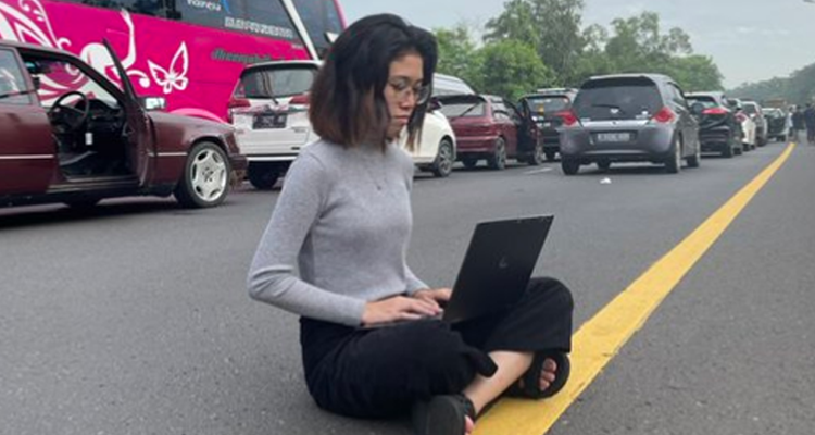 Potret yang belakangan viral di Twitter, wanita yang tetap bekerja di tengah kemacetan.