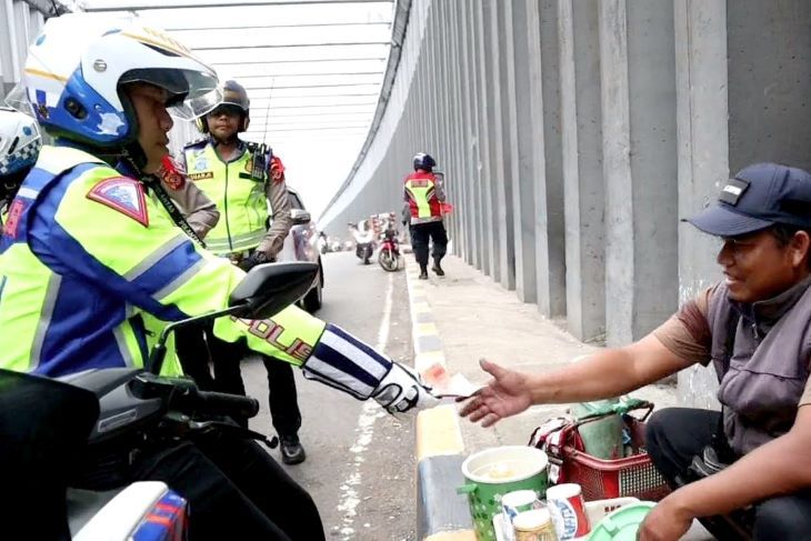 Kasat Lantas Polresta Bandung Kompol Rislam Harfian berbagi rejeki sekaligus memberikan himbauan kepada  pedagang di terowongan Jalan Lingkar Nagreg, Jawa Barat, Rabu 4 Mei 2022.
