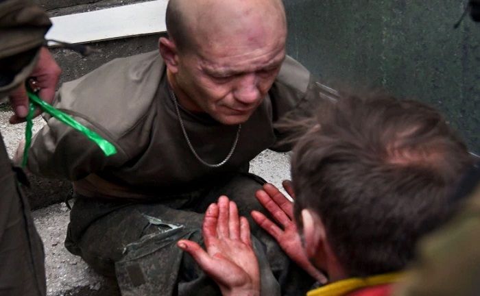 Vitalii Seleveni menyodorkan tangannya yang berlumuran darah ke wajah seorang tentara Rusia yang ditangkap.*  