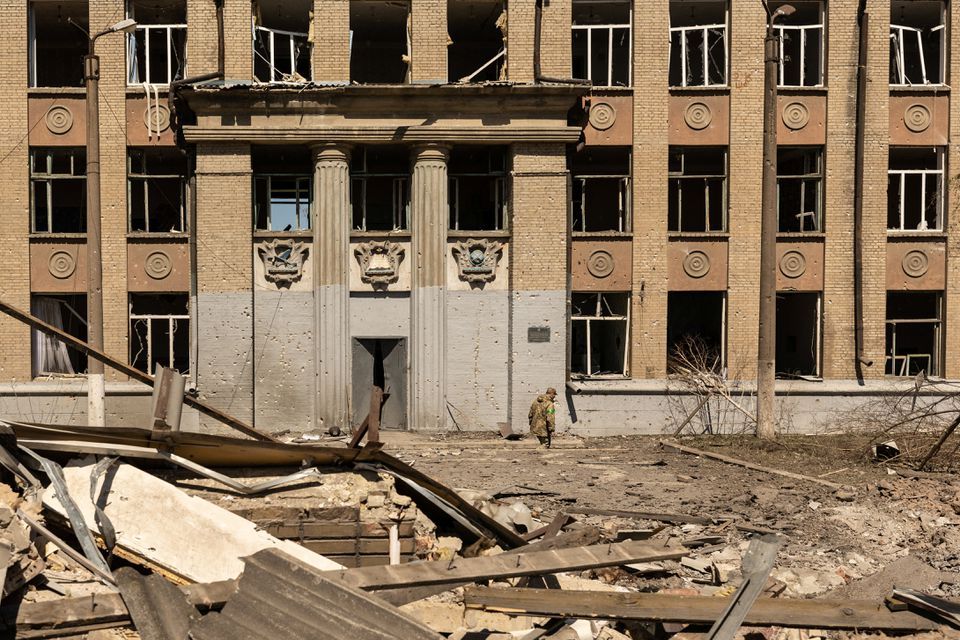 Seorang tentara Ukraina berjalan di depan sebuah sekolah yang dibom di tengah invasi Rusia di Ukraina, di Kostyantynivka, di wilayah Donetsk, Ukraina, 8 Mei 2022.   