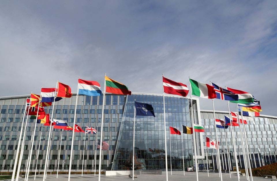 Bendera berkibar di luar markas Aliansi menjelang pertemuan Menteri Pertahanan NATO, di Brussels, Belgia, 21 Oktober 2021./    