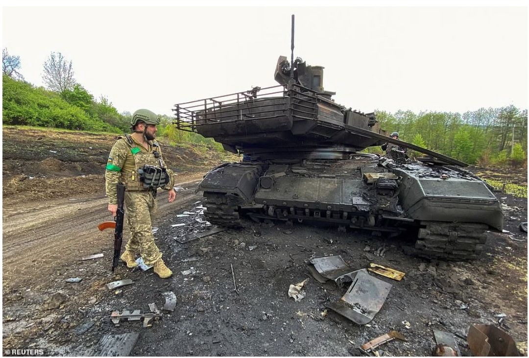 Seorang prajurit Ukraina berjalan di samping tank tempur utama Rusia T-90M Proryv yang hancur, di Staryi Saltiv di wilayah Kharkiv pada 9 Mei.