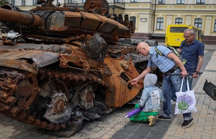 Orang-orang sedang melihat pameran bangkai tank bebek duduk Rusia yang dihancurkan pejuang Ukraina.*  