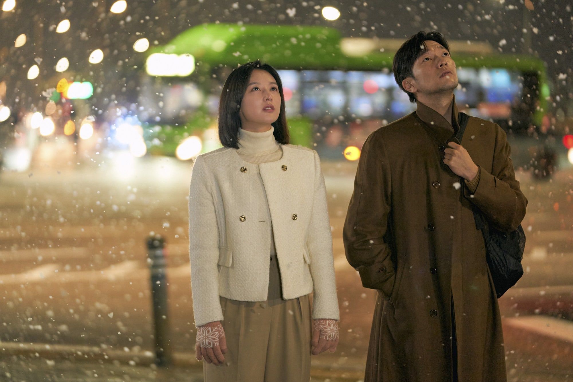Kim Ji Won dan Son Seok Gu saling memandang dengan sedih di tengah salju yang turun di My Liberation Notes. 