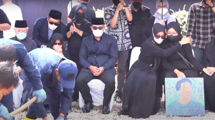 Dipeluk sang bunda, Zara tampak memegang lukisan Eril saat prosesi pemakaman sang kakak. /YouTube Humas Jabar