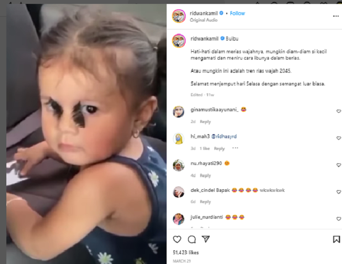 Anak kecil yang merias wajahnya sendiri menggunakan bulu mata yang terbalik