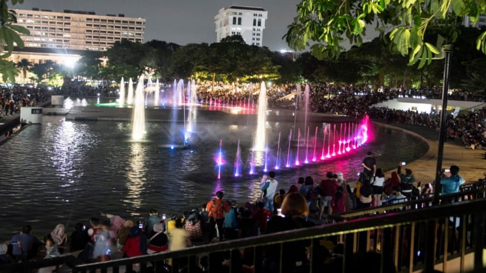 Warga menyaksikan pertunjukan air mancur menari di Lapangan Banteng, Jakarta,.