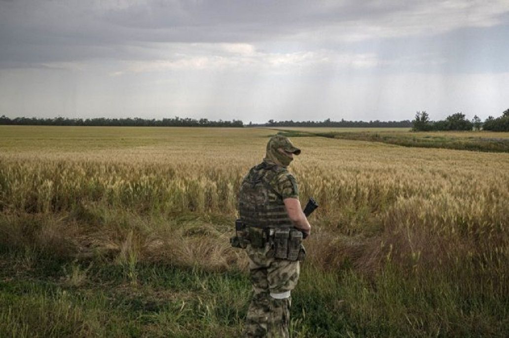 Seorang tentara Rusia berjaga-jaga di depan ladang gandum dekat Melitopol di wilayah Zaporizhia, Ukraina, Selasa. 