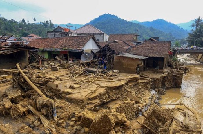  Warga menyelematkan barang yang tersisa dari tumpukan bangunan rumah yang rusak akibat banjir bandang di Desa Purasari, Leuwiliang, Kabupaten Bogor, Jawa Barat.