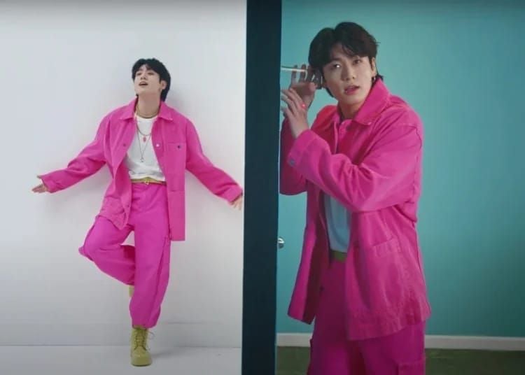 Penampilan Jungkook BTS yang kenakan setelan berwarna pink elektrik yang berani. 