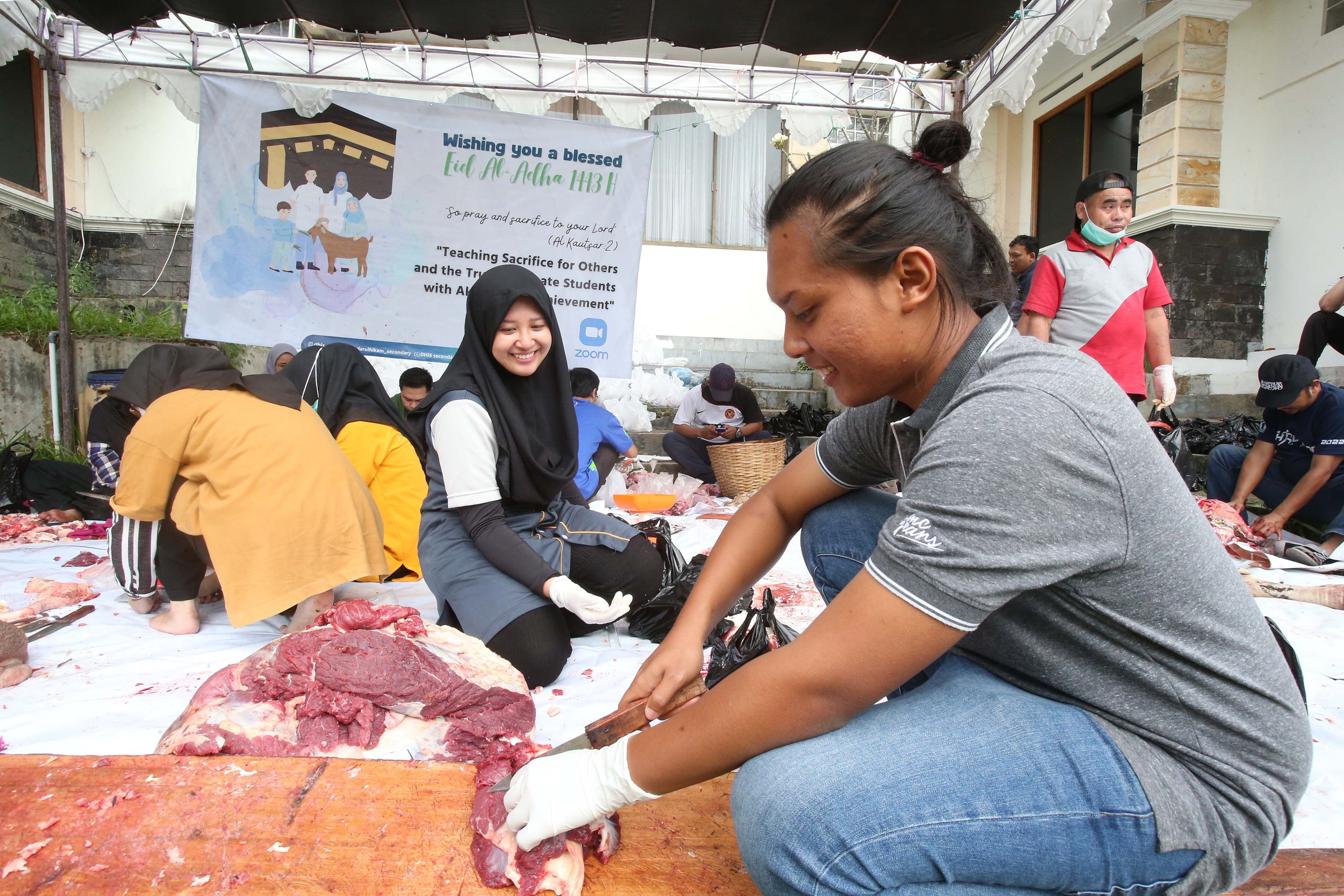 Kepala Sekolah Darul Hikam Integrated School (DHIS) Binar Kasih mencacah daging kurban dengan alumni DHIS Sulton yang berprofesi sebagai peternak sapi, di Kampus DHIS, Jalan Maribaya, Kabupaten Bandung Barat, Selasa,   12 Juli 2022. 