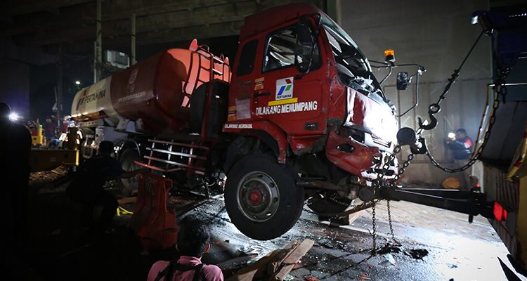 Petugas menggunakan mobil derek untuk mengangkat kepala truk pengangkut bahan bakar minyak (BBM) yang mengalami kecelakaan maut di Jalan Transyogi, Cibubur, Bekasi, Jawa Barat, Senin 18 Juli 2022.