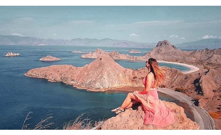 Seorang Wisatawan Berpose dengan latar Keindahan Pulau Padar