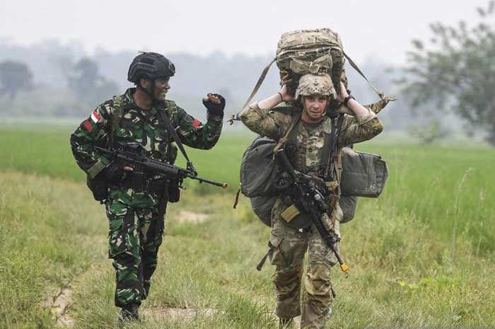 Prajurit TNI Angkatan Darat sedang berjalan bersama dengan seorang prajurit Angkatan Darat Amerika Serikat atau US Army.