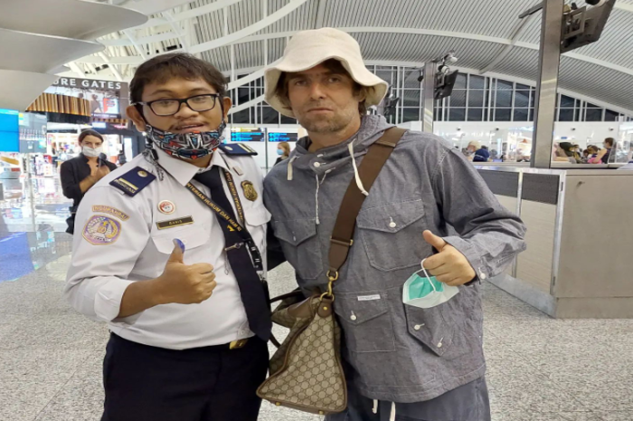  Seorang petugas imigrasi di Bandara Ngurah Rai Bali berfoto dengan musisi Liam Gallagher, Rabu, 10 Agustus 2022. 