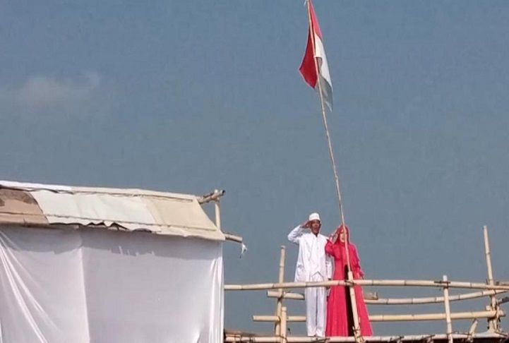 Pasangan Herman Bambang Hermanto dan Lilis mengibarkan bendera Merah Putih dan menyanyikan lagu Indonesia Raya di tengah laut Teluk Banten, Karangantu, Kecamatan Kasemen, Kota Serang, Rabu 17 Agustus 2022.