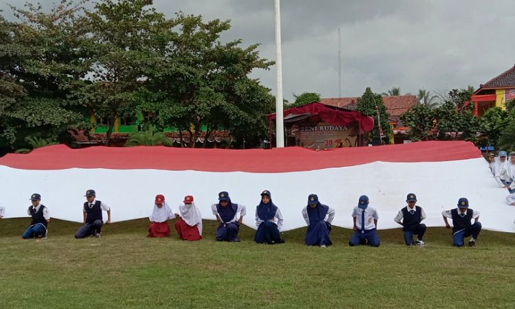 Bendera merah putih sepanjang belasan meter dibentangkan saat upacara di lapangan Merdeka Pangandaran.