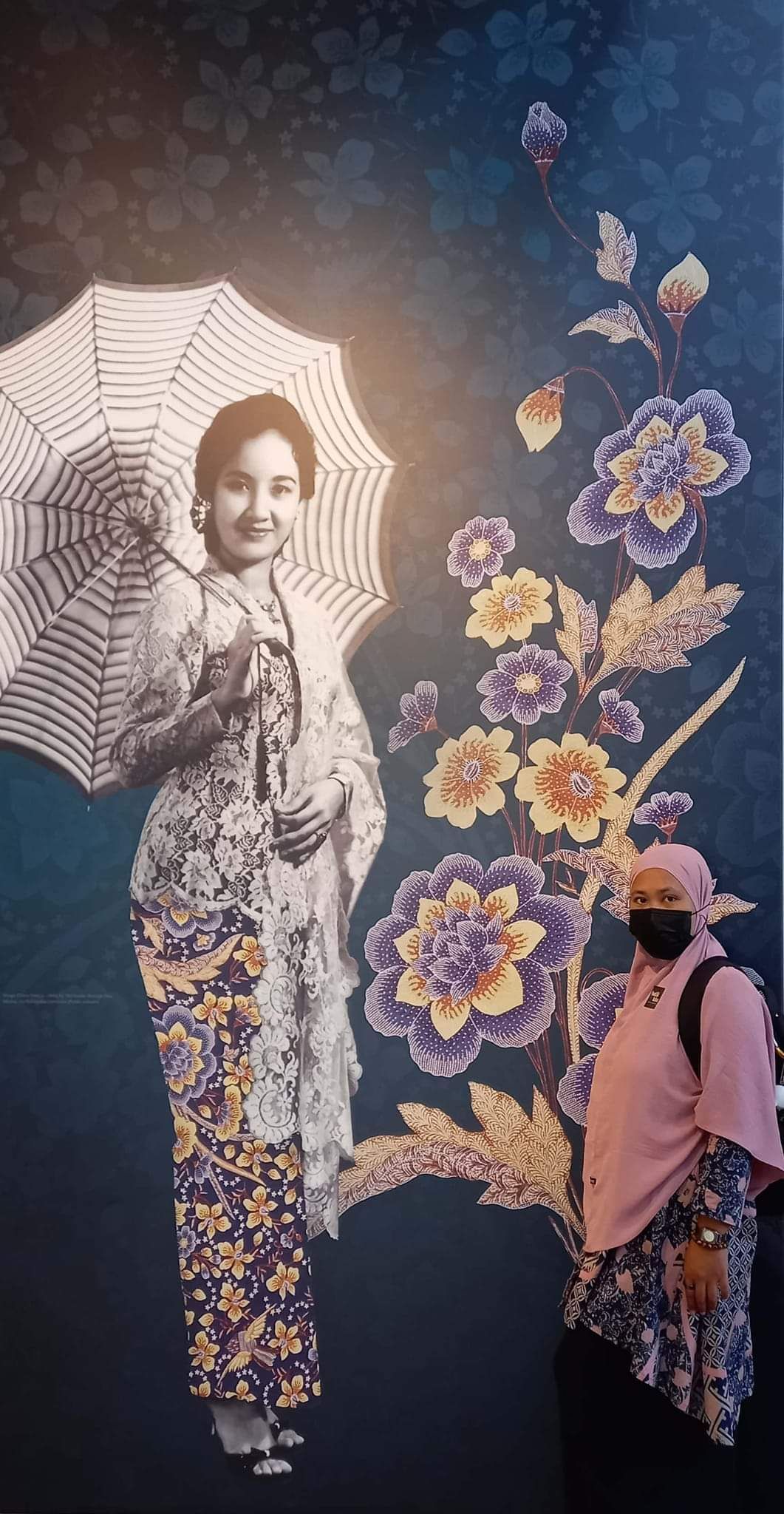 Maimunah Subagio mengenakan batik modern dengan motif Sekar Jagad ( perwakilan VEI )berfoto di depan foto Chitra Dewi ( artis dan director yang terkenal di tahun 70-an )