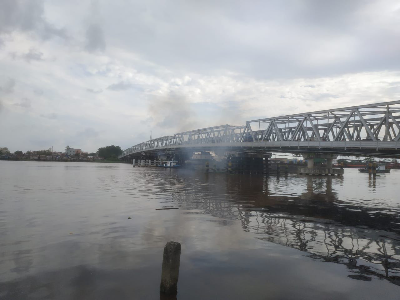 Kepulan asap keluar dari jembatan Landak pasca ditabrak oleh kapal tongkang 