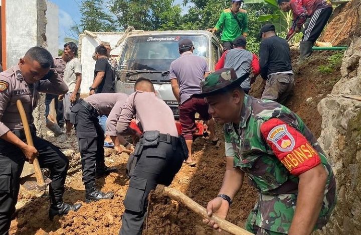 Anggota Polres Banjarnegara bersama Koramil Punggelan melakukan kerja bakti pembersihan material longsor di lokasi longsor yang menimpa rumah warga desa Jembangan pada Senin 12 September 2022