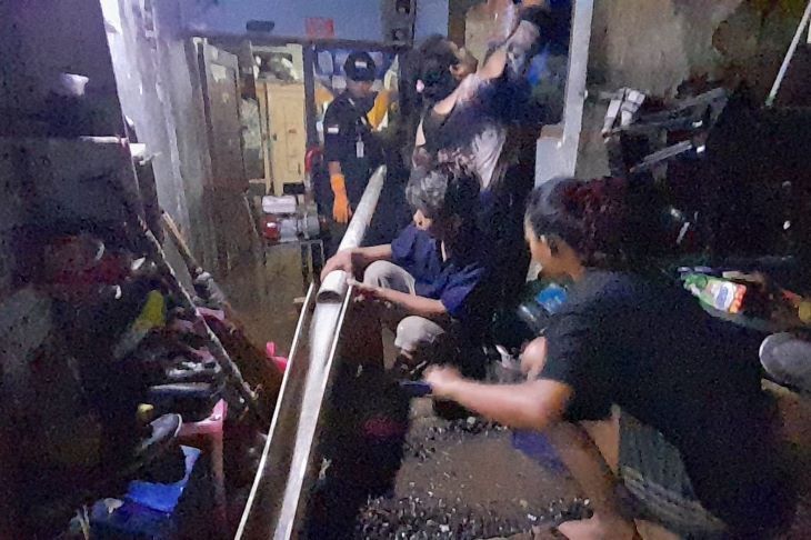 Warga menyalurkan air yang merendam rumah mereka di  RW 20 Kelurahan Baros, Kecamatan Cimahi Tengah, Kota Cimahi  dengan alan seadanya.