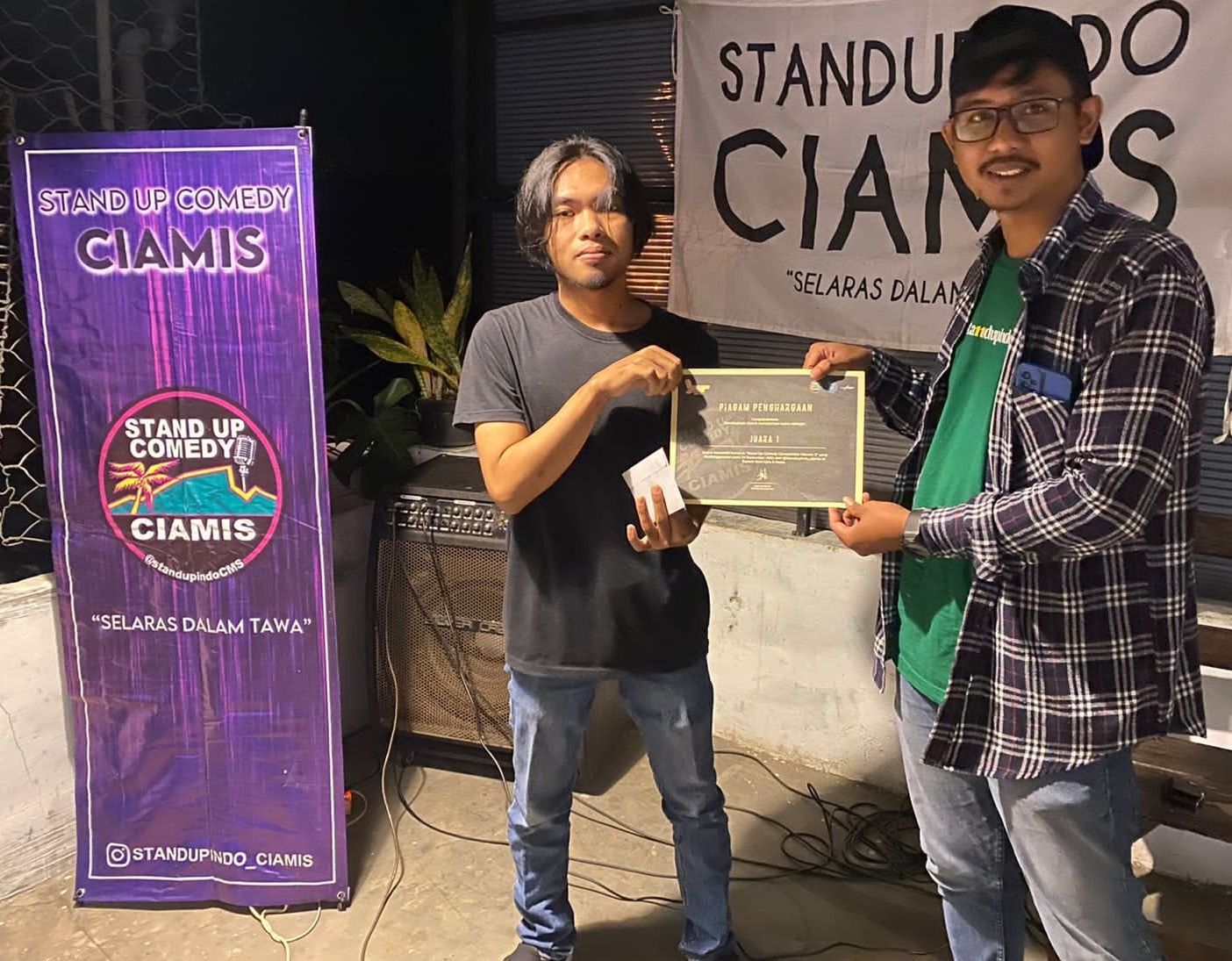 Juara kompetisi stand up comedy volume 2, Rayhan Maulana menerima piagam dari ketua panitia, Andi Beng