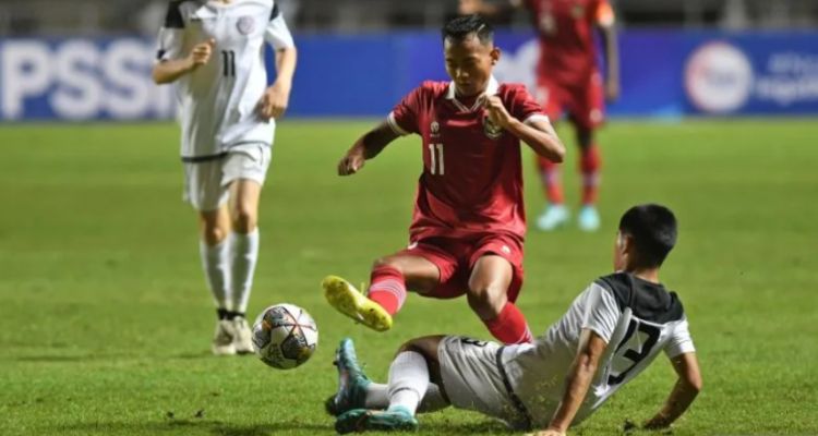 Pesepak bola Tim Nasional U-17 Indonesia Riski Afrisal (atas) berebut bola dengan pesepak bola Tim Nasional U-17 Guam Nicholas Moore (bawah) dalam laga Grup B Kualifikasi Piala Asia U-17 2023. 