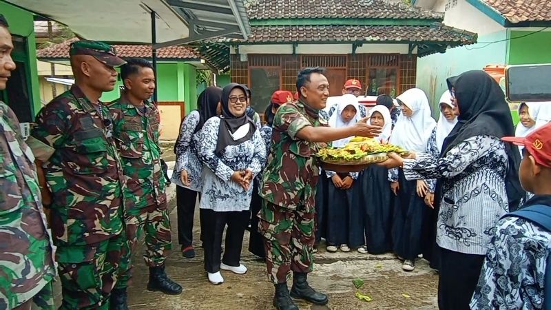 Pelajar SD dan PGRI serta Dinas Dikpora Kab Pangandaran sedang menyerahkan nasi tumpeng kepada salah satu anggota TNI AD di Makoramil 1320 Pangandaran, Rabu 5 Oktober 2022.