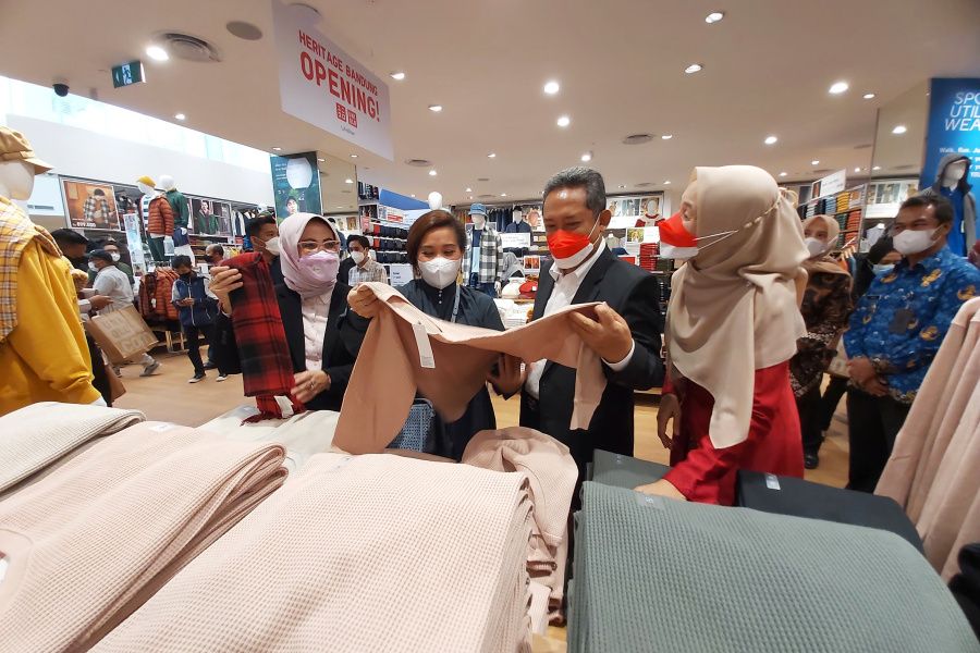 Wali Kota Bandung, Yana Mulyana (kedua kanan) melihat-lihat pakaian seusai peresmian toko Uniqlo Heritage Bandung.