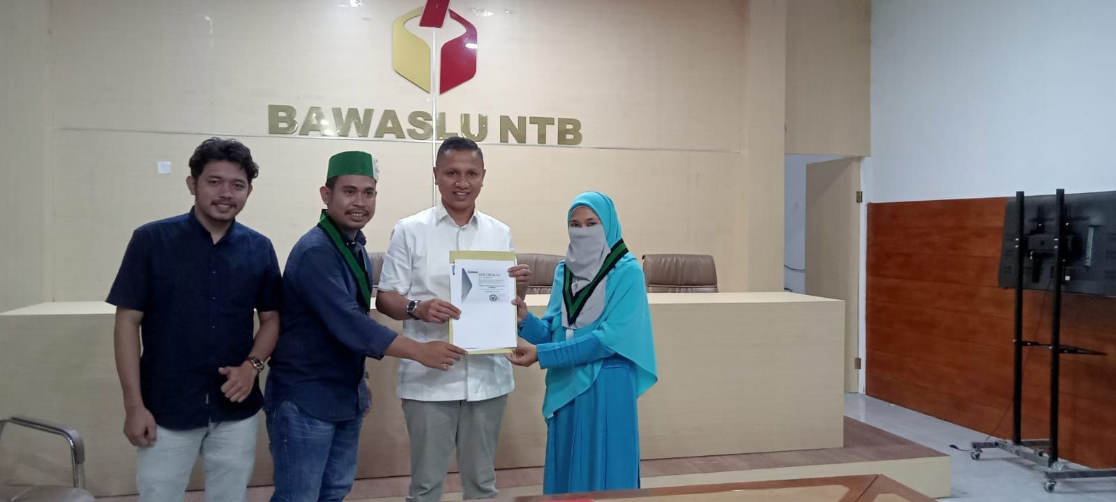 Ketua Umum Kohati Badko Bali Nusra Rina Marwati saat menyerahkan dokumen akreditasi pemantau Pemilu kepada anggota Bawaslu NTB, Hasan Basri, 8 November 2022 lalu.