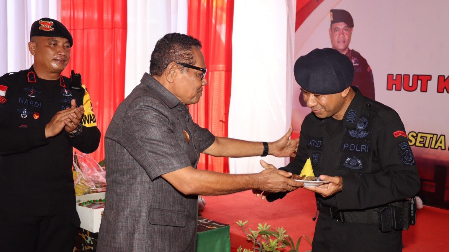Wakil Bupati Alor, Imran Duru, S.Pd, M.Pd memberikan tumpeng kepada anggota Brimob Tertua dalam perayaan HUT Brimob di Alor di 