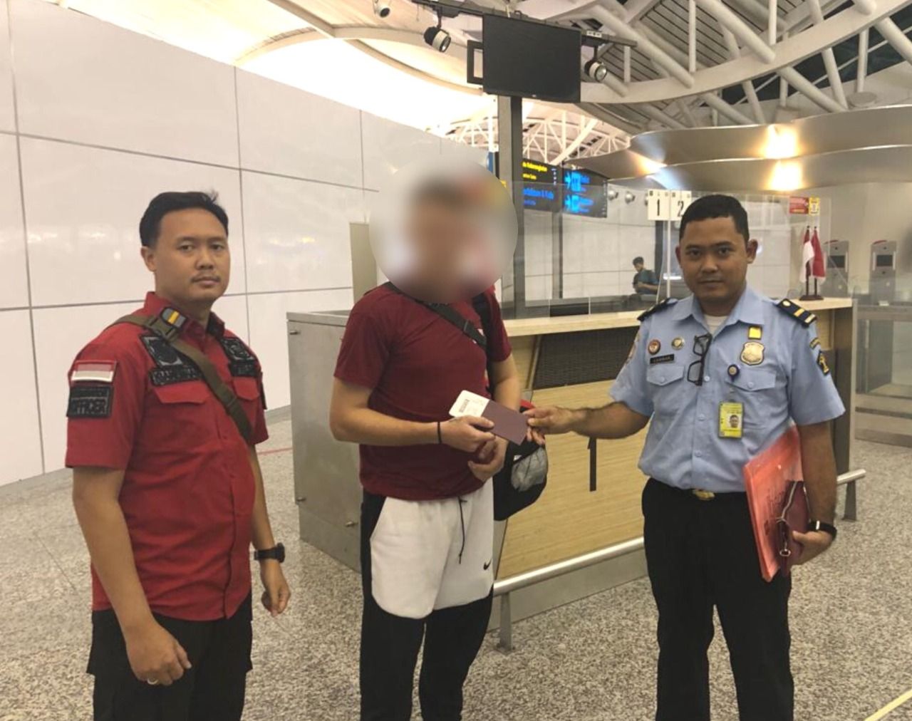 Petugas tengah mendampingi WNA Polandia ( tengah) yang dideportasi karena tersandung kasus skimming dan sudah menjalani masa hukuman di Karangasem Bali.
