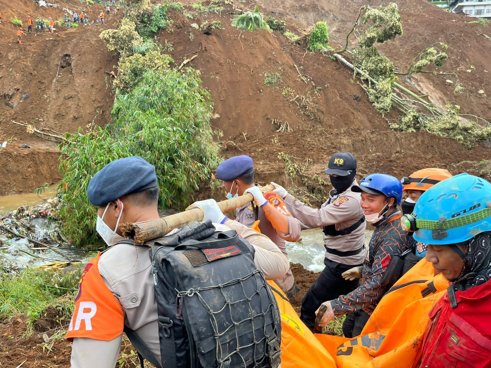 Personil kepolisian saat menandu jasad korban bencana tanah longsor di Kecamatan Cugenang, Kabupaten Cianjur