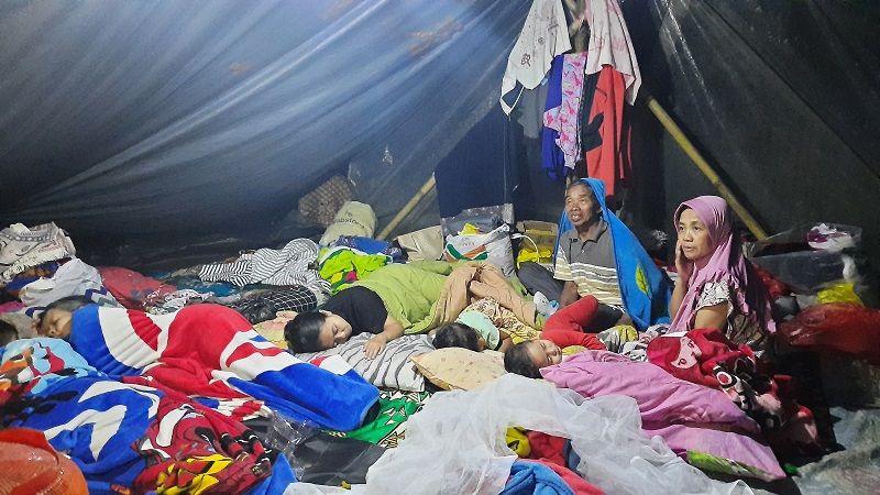 Warga bermalam di tenda pengungsian, Kampung Mangun, Desa Mangunkerta, Kecamatan Cugenang, Kabupaten Cianjur, Kamis (24/11/2022) malam. Penyaluran bantuan gempa Cianjur dinilai masih sporadis.