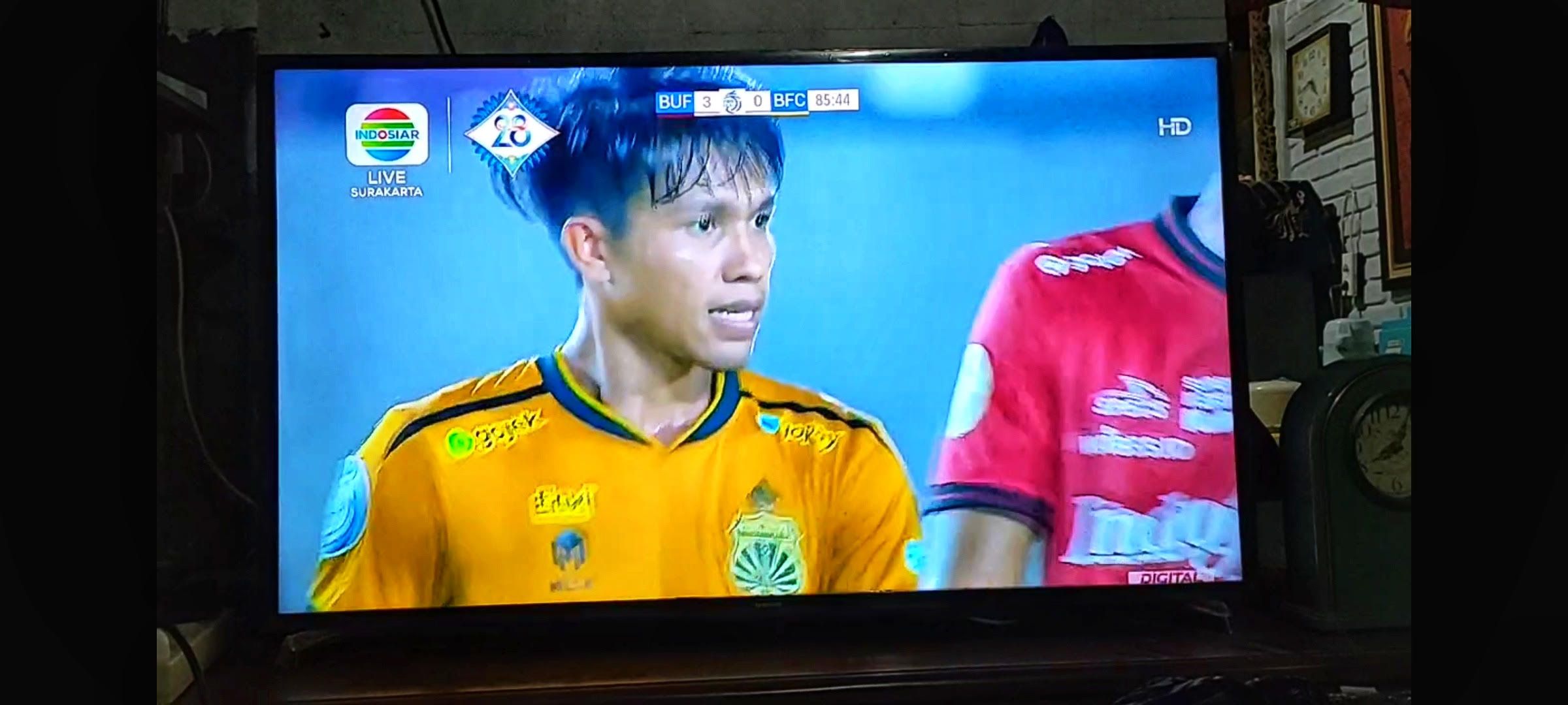 Salah seorang warga menikmati siara televisi digital saat menonton liga Indonesia pada Kamis 8 Desember 2022
