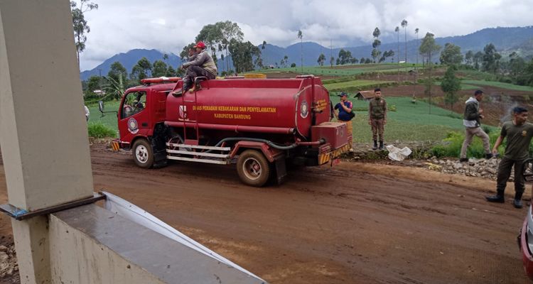 Pembersihan material lumpur usai banjir di depan Mapolsek Kertasari, Kabupaten Bandung, Jumat 9 Desember 2022.